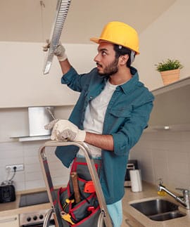 Profesional de Rossel Multiservicios realizando trabajos eléctricos en una cocina